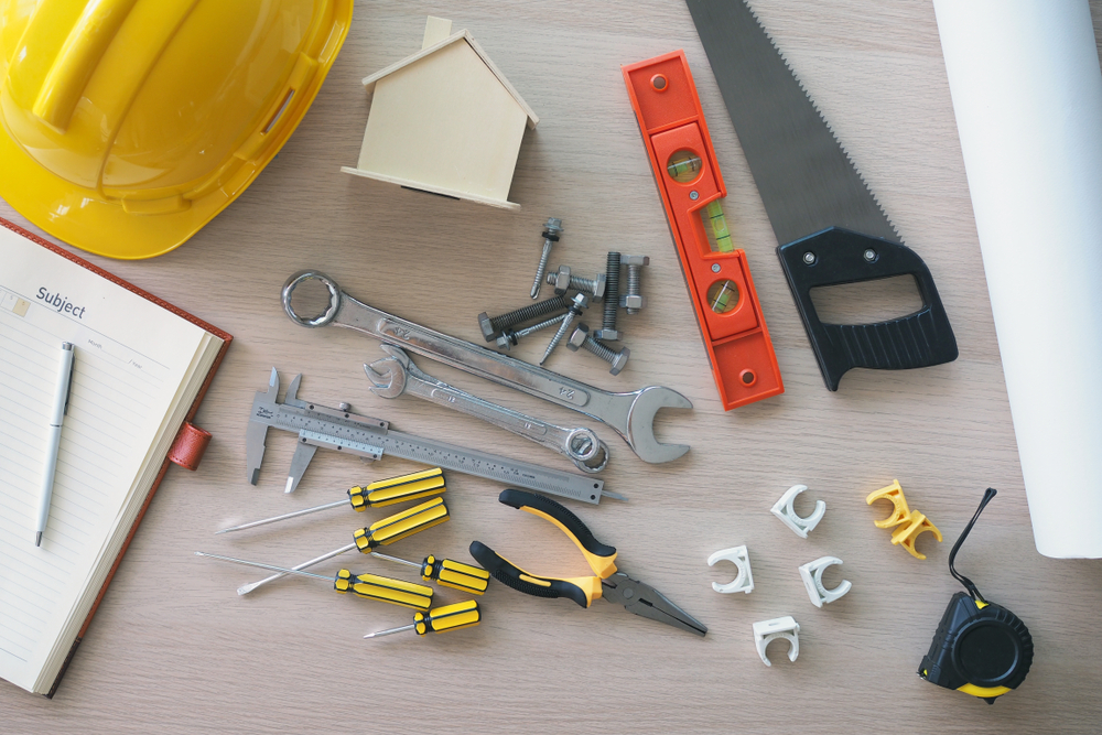 Construction worker in front of a house exterior, working on renovation project.